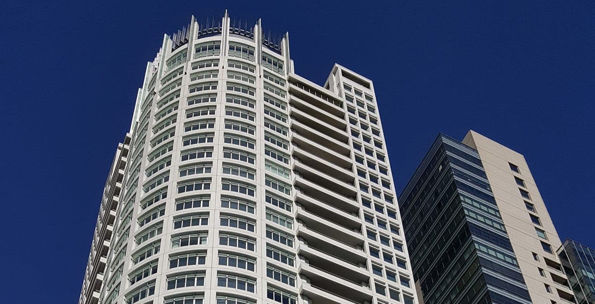 Motorized shades lowered in unison across a commercial curtain wall